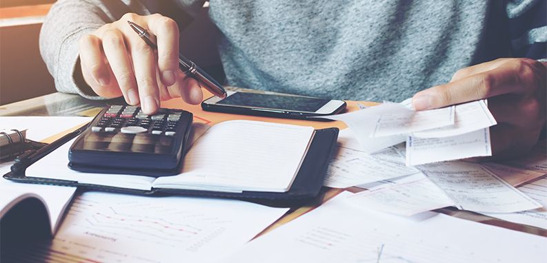 Paragon fiskalny w dłoni osoby, która oblicza wydatki w domowym budżecie
