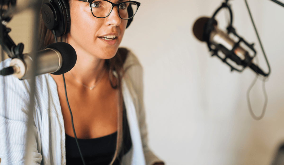Kobieta w studio nagrań zastanawia się, jak zacząć nagrywać podcasty